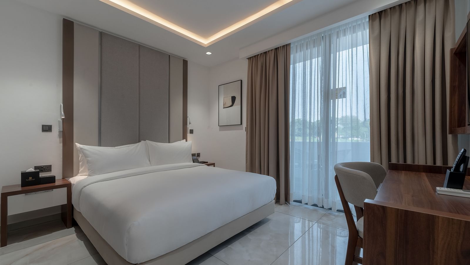 Spacious Standard Room with king size bed, soft lighting, wooden desk, large window, and cozy ambience. - The Pelican Hotel, Accra