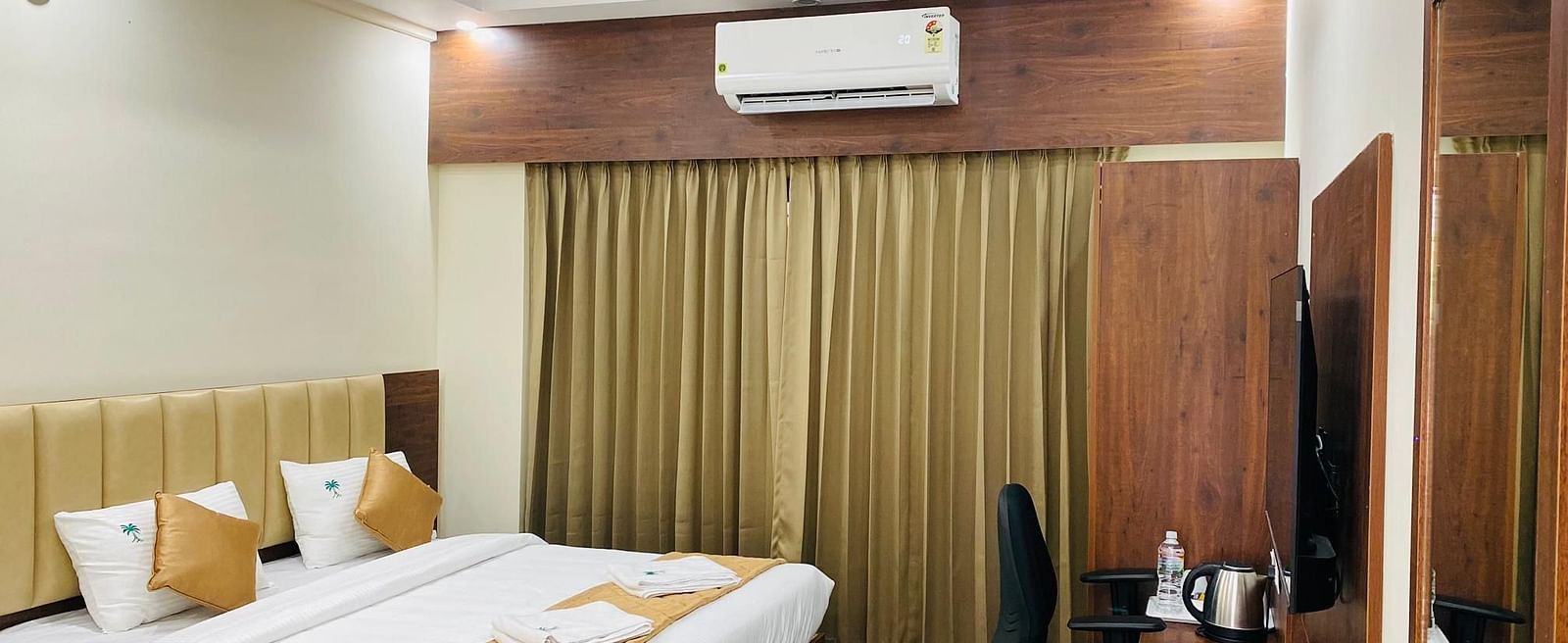 Elegant room featuring large bed, full-length curtains, and cosy ambience at Hotel Sahara Tree.
