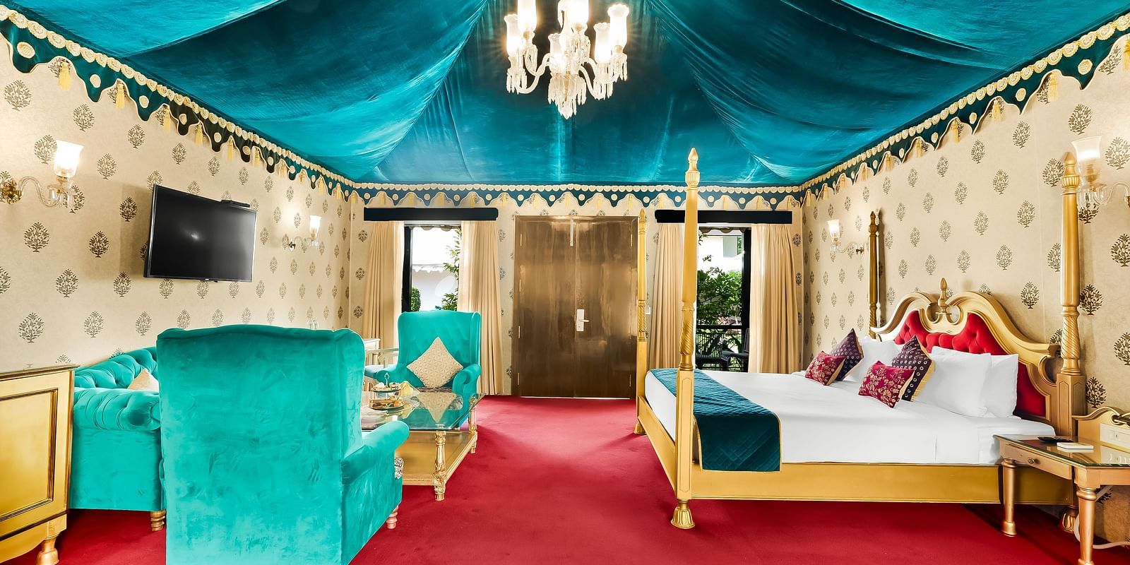 An overview of a tent with a double bed, sofas and a coffee table - Rajasthali Resort & Spa, Jaipur.