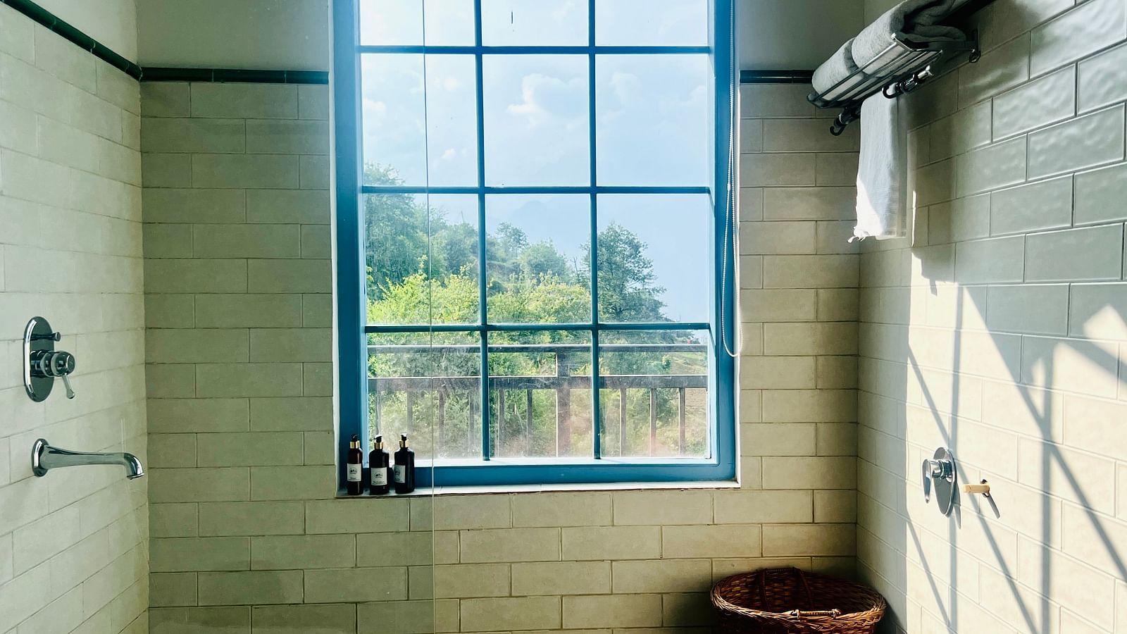 Contemporary bathroom with natural light, a large soaking tub, and sleek fixtures with a mountain view | Faraway Cottages, Auli