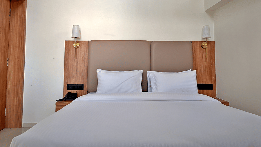 Bedroom with a double bed, wooden headboard, and bedside lights.