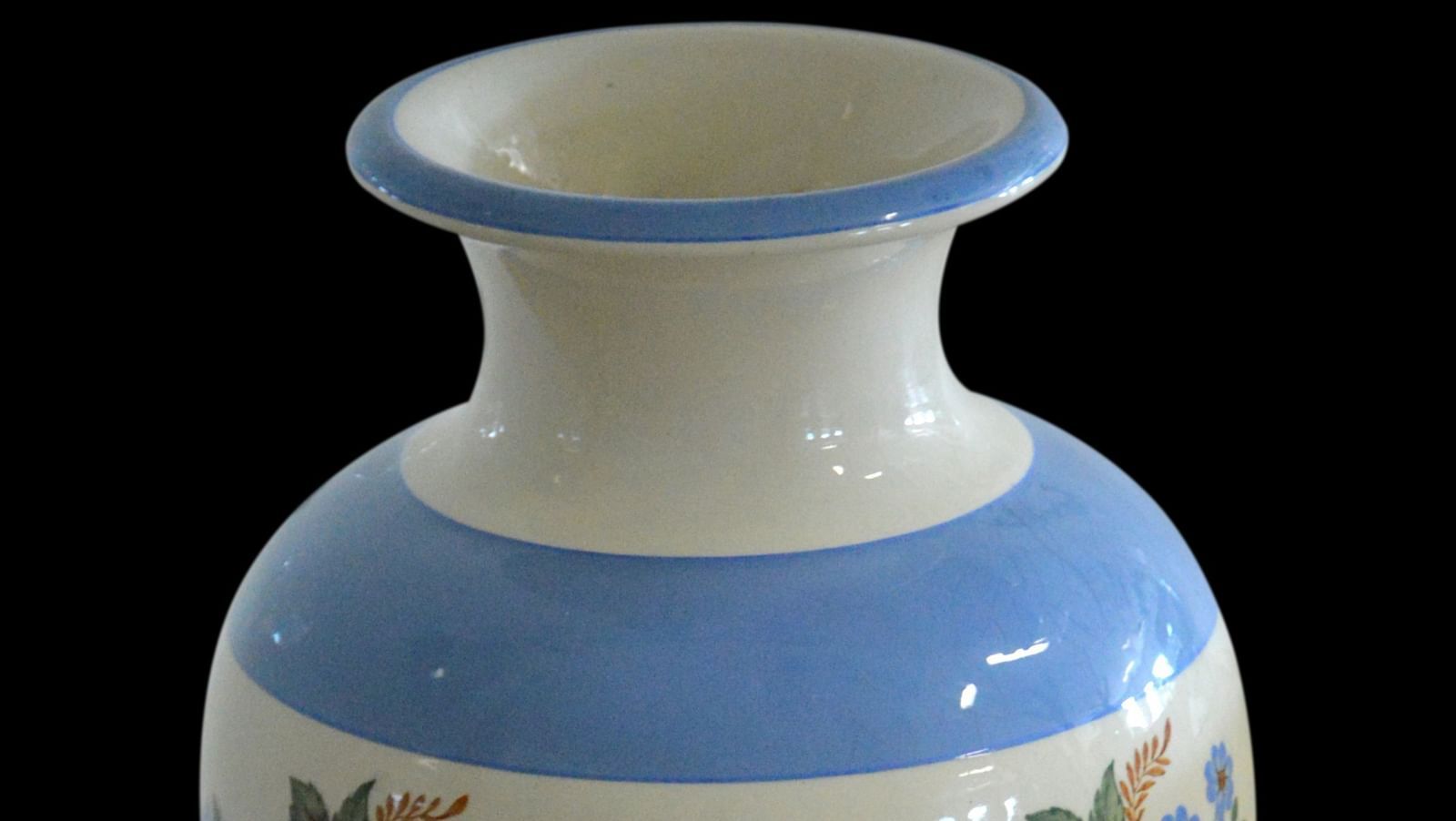 An overview of a chinese flower vase with blue borders and black background.