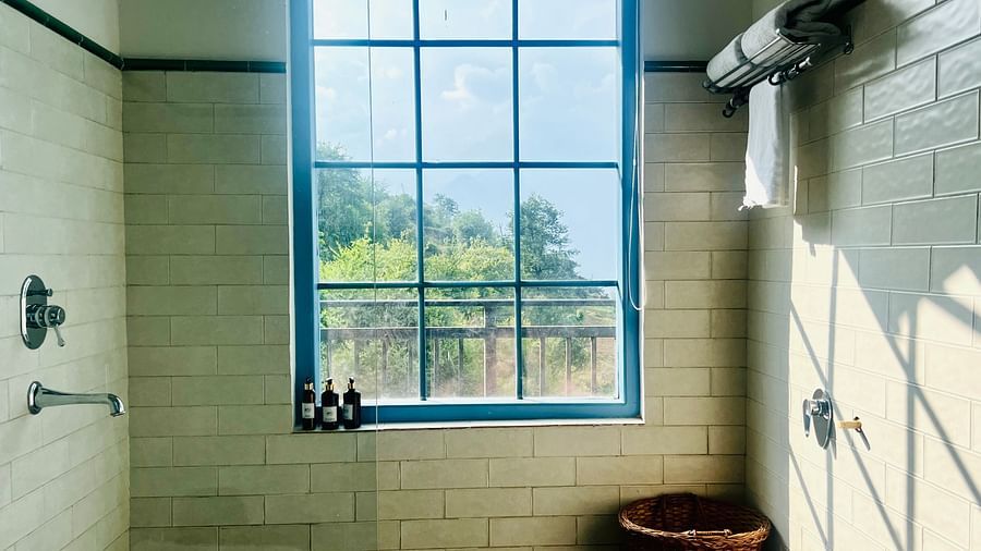 Contemporary bathroom with natural light, a large soaking tub, and sleek fixtures with a mountain view | Faraway Cottages, Auli