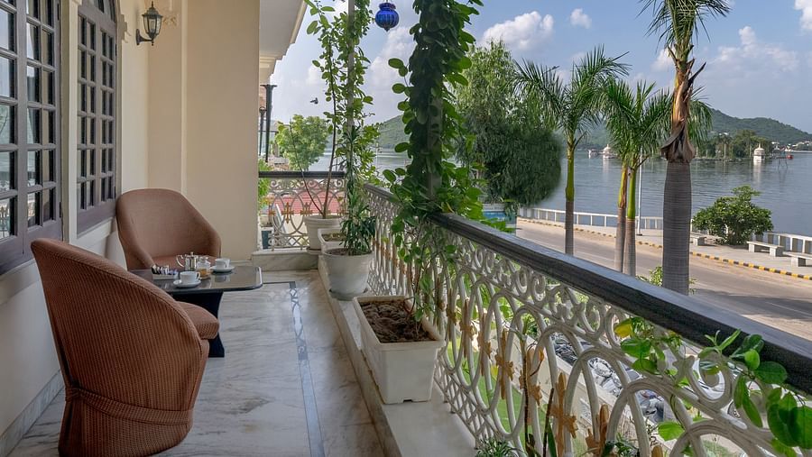 A balcony with two cushioned seats offering a view of the lake| Panna Vilas Udaipur