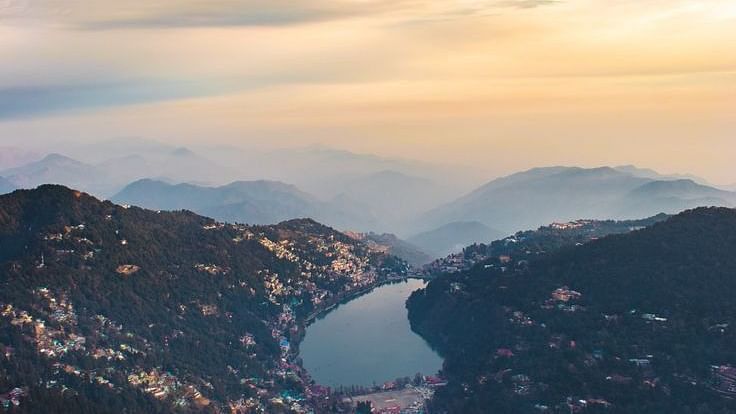 An overview of Nainital with a serene lake and sunlit sky in view.