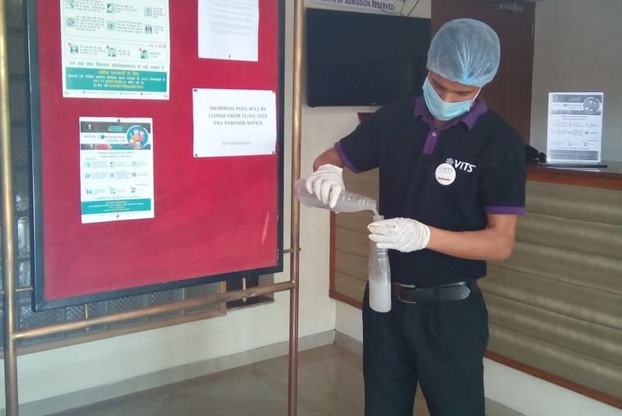 a staff member cleaning the notice board at one of the hotels - VITS Hotels & Resorts