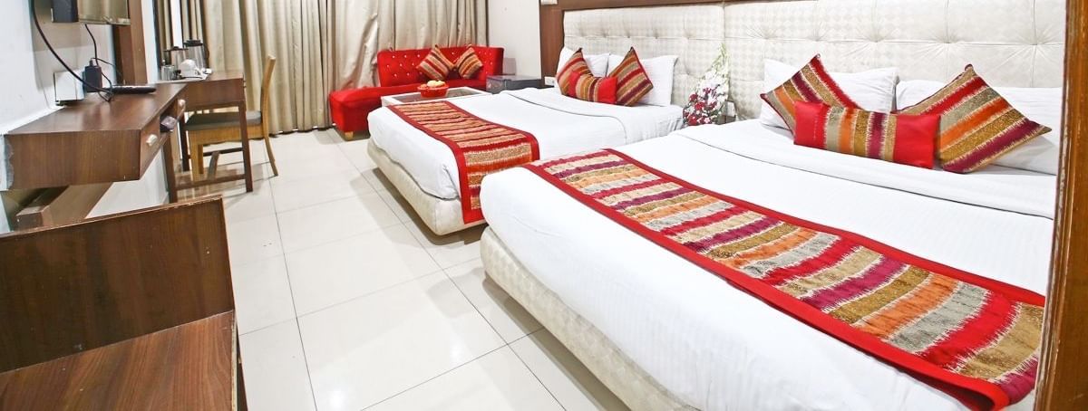Spacious room with bed, sofa and window view at Hotel Diamond Plaza, Chandigarh