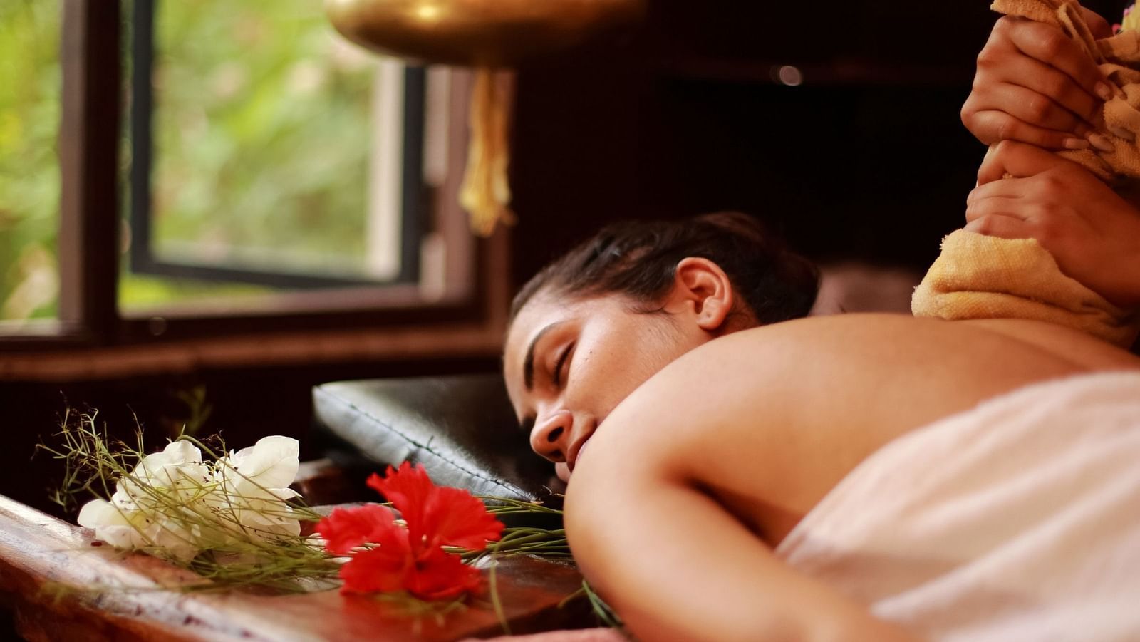 an image of a woman attending a spa therapy - best resort in Lonavala for group - Rhythm Lonavala