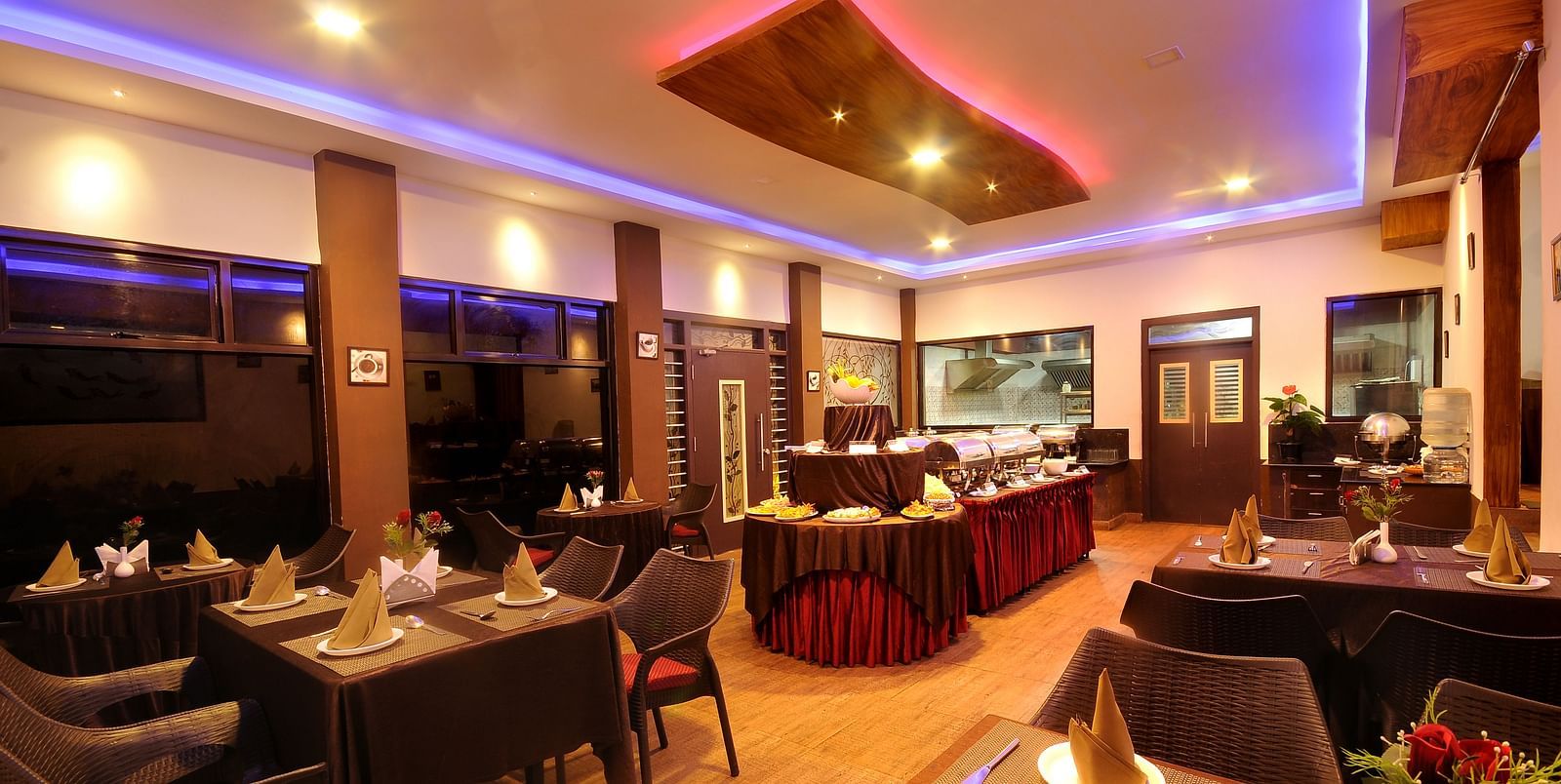 Image of a dining space with tables and chairs and lights on the ceiling at Parampara Resort & Spa, Kushalnagar.