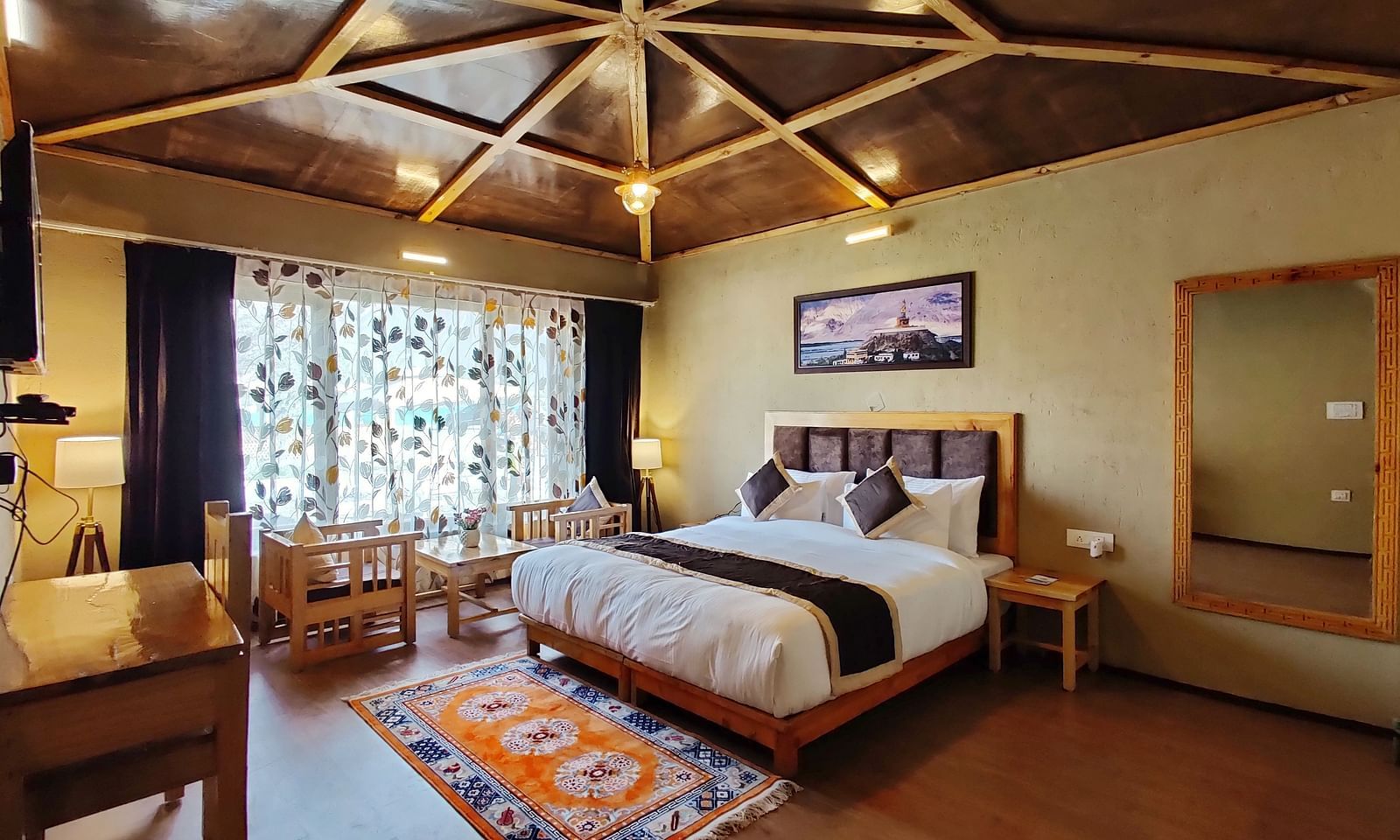 Premium Cottage at White Sands Resort, Ladakh , showcasing a king size bed, wooden accents, and a rug with a different pattern.