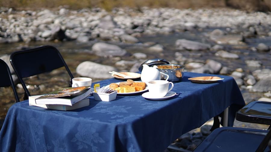 A breakfast table placed right besides a stream of water during the day