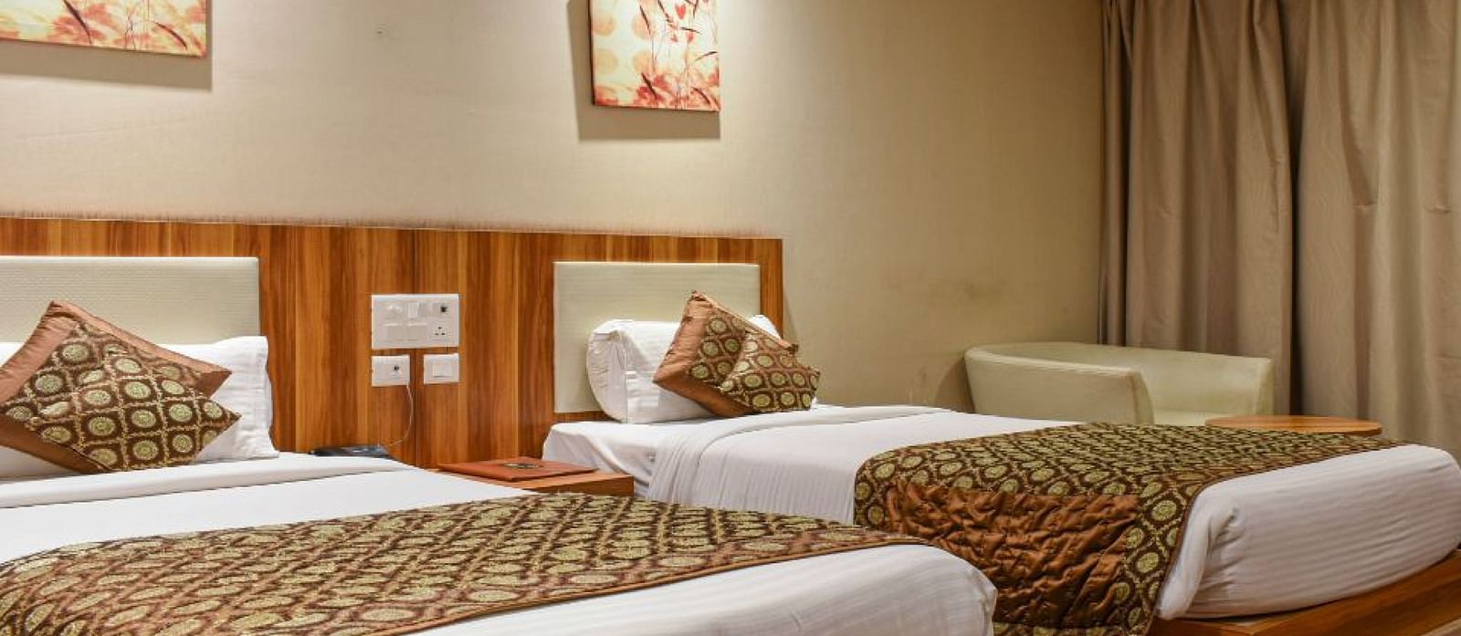 corporate room with twin beds and warm lighing at le roi raipur hotel