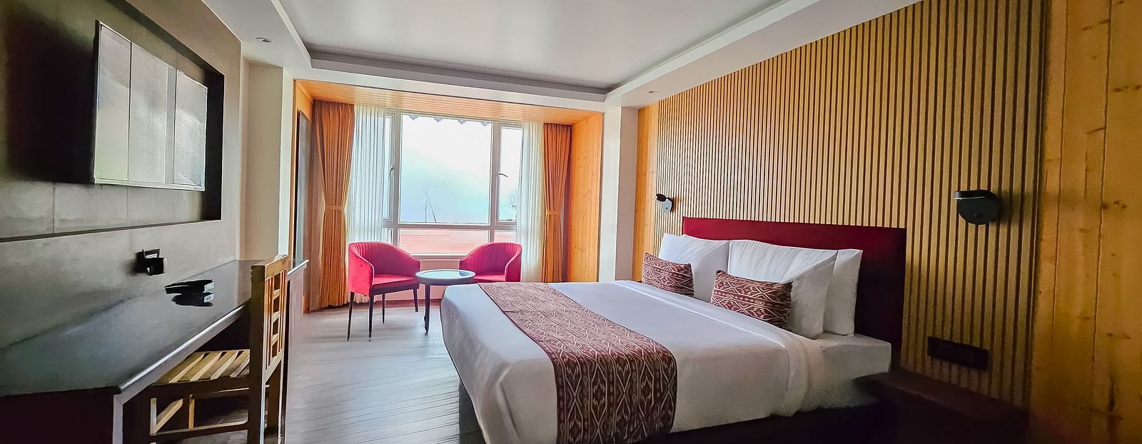 A bedroom with wooden interiors and a false ceiling right above the double bed - Yashshree Lachen
