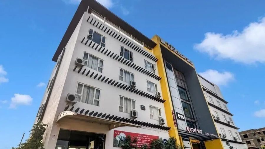 The exterior of a modern multi-story hotel building with yellow and grey accents under a blue sky - VITS Select Kailash Inn, Bagalkot