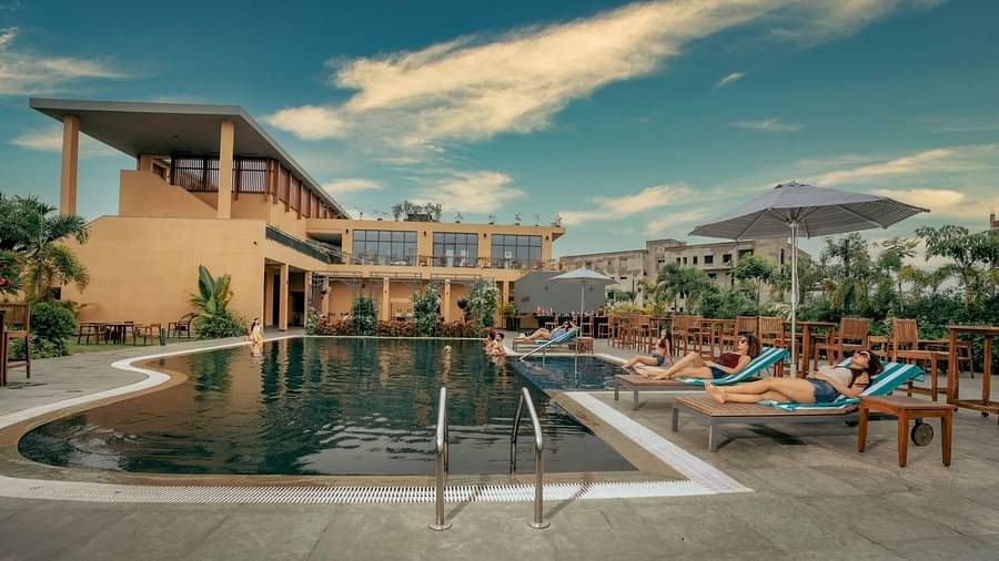 Outdoor swimming pool at at Singalila Club with lounging chairs placed along the periphery