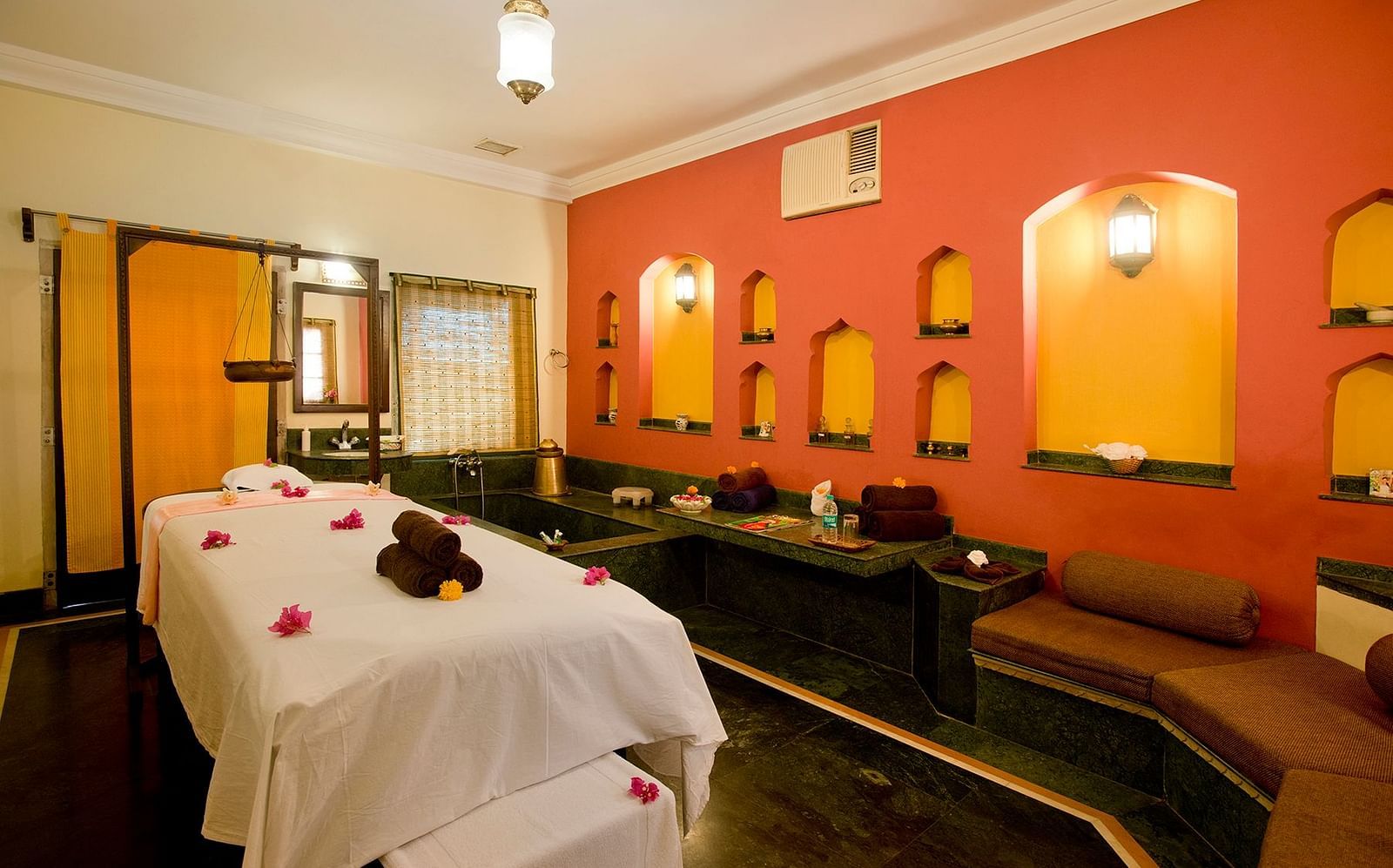 A cosy spa room at The Haveli Hari Ganga in Haridwar features a comfy bed and soft lighting, creating a relaxing atmosphere perfect for unwinding and rejuvenation.
