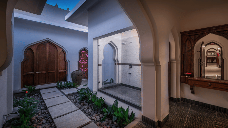 Whitewashed resort courtyard with arched doorways at Evolve Back Hampi