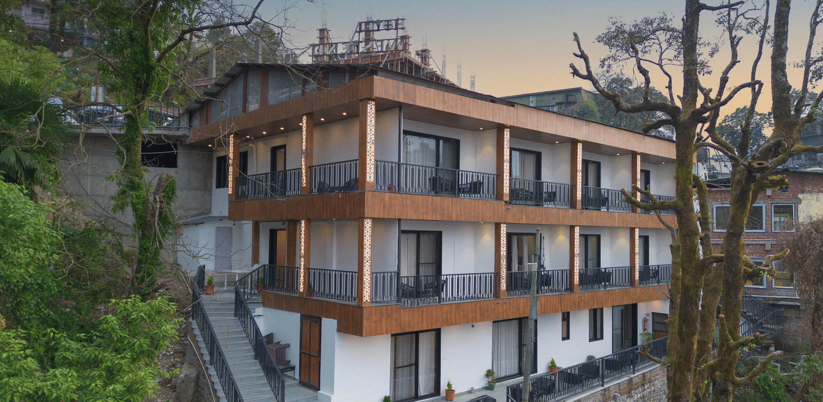 A beautiful facade of the Perfectstayz Premium Westend Mall Road, Mussoorie, featuring a 3-storey building with balconies.