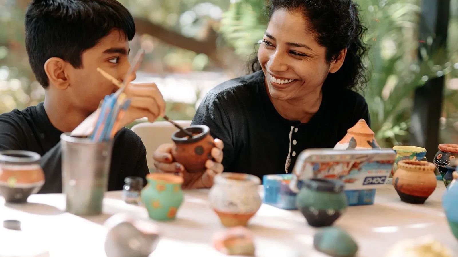A lady and a young kid participating in art & craft session at Daksh Resort & Amusement Park.