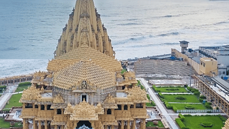 An aerial shot of a large temple complex and the sea.