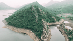 A aerial view of a mountain in between a water body