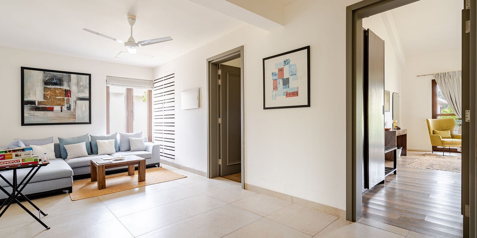 Spacious living area at Lindsay Manor with sofa set, wall paintings, and open doorways leading to other rooms.