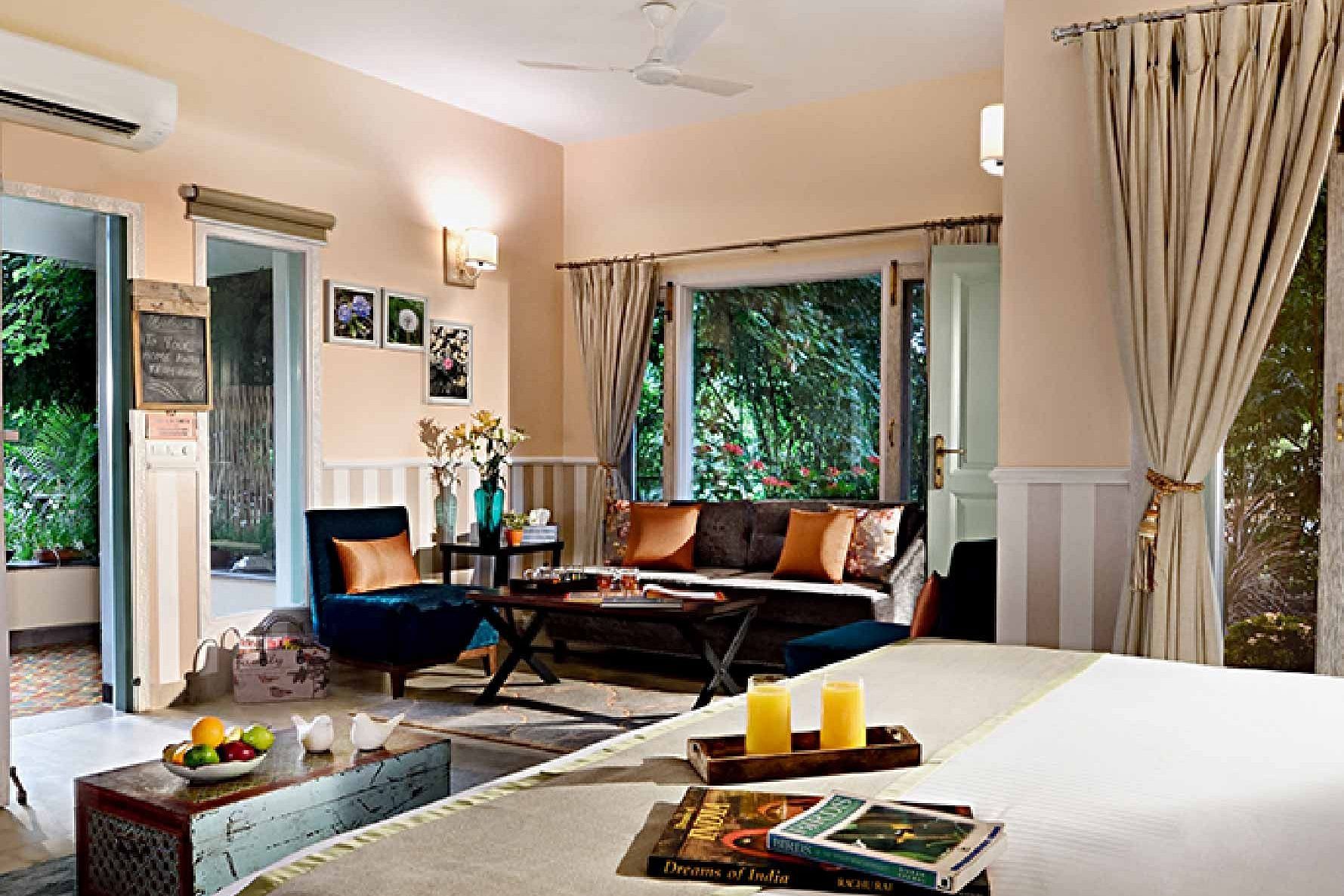 Interior of a guest room with a double bed, sofa, and window view at Karma Chalets.