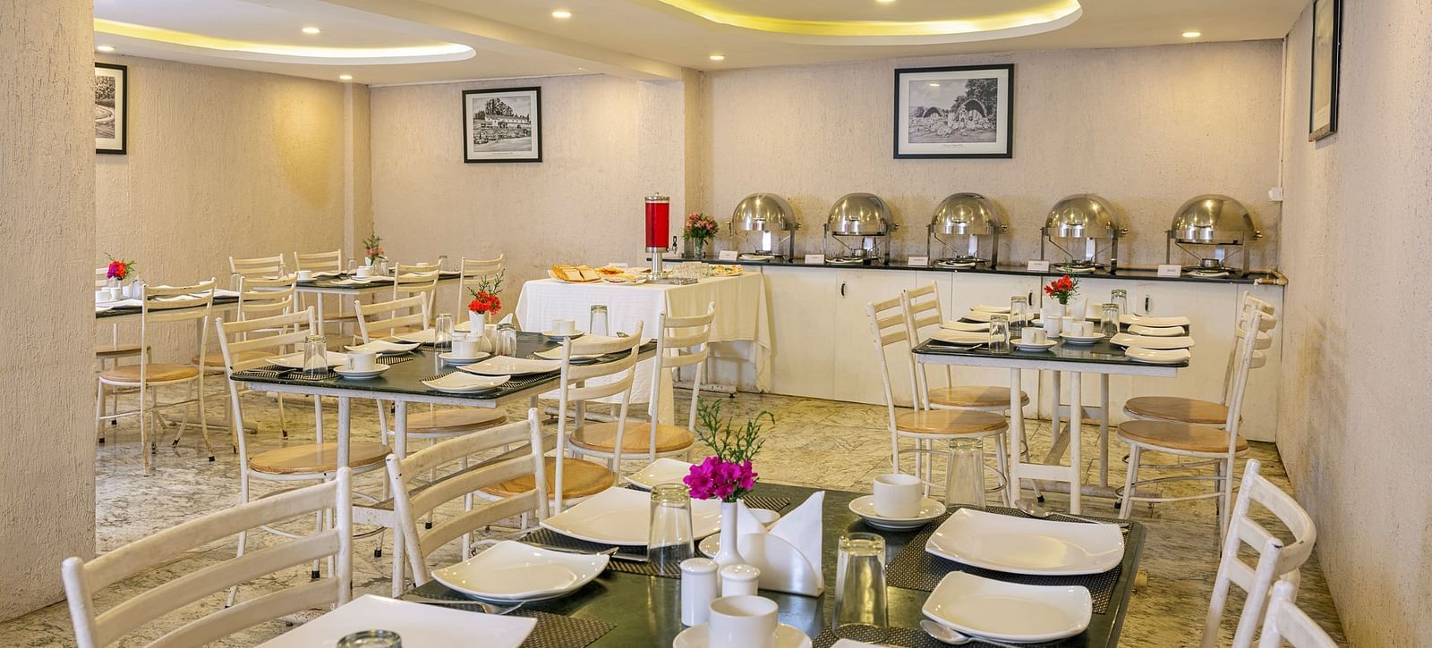 Elegant restaurant interior with buffet tables and decorative lighting | Mango HIll Central, Ooty