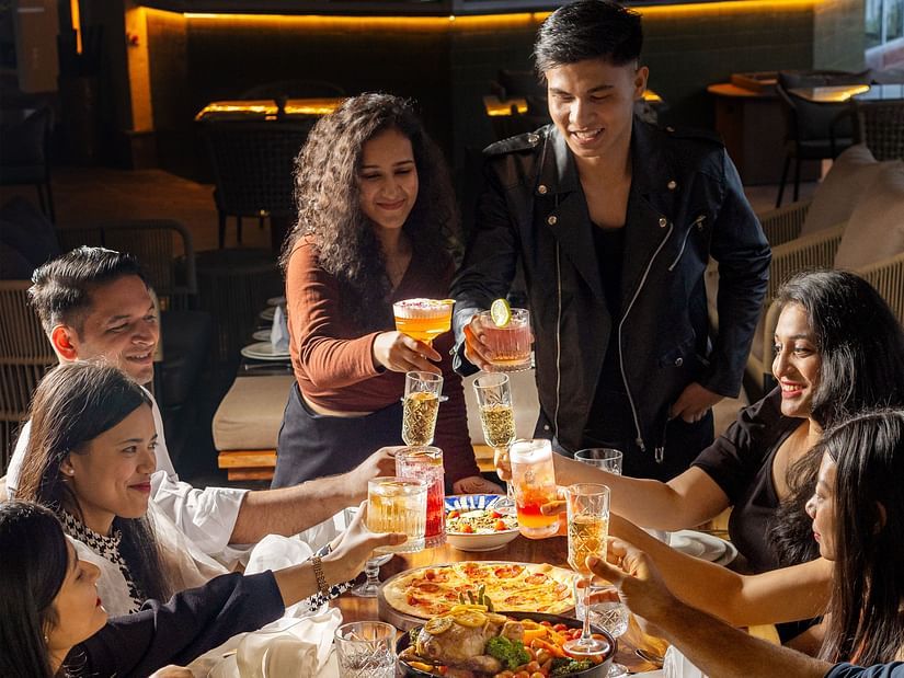 Group of friends celebrating with food and drinks at The Dukes Retreat’s vibrant dining space