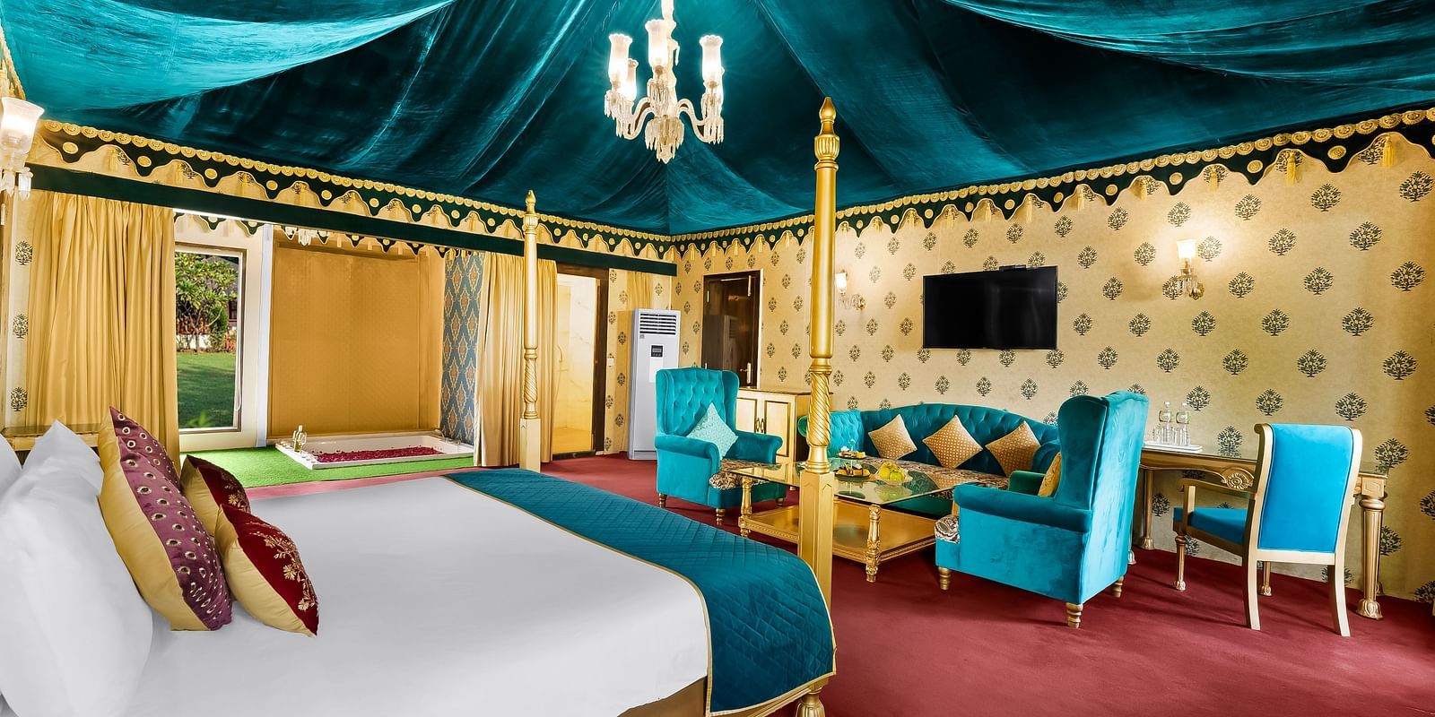 An overview of a tent with a double bed, sofas and a table seen - Rajasthali Resort & Spa, Jaipur.