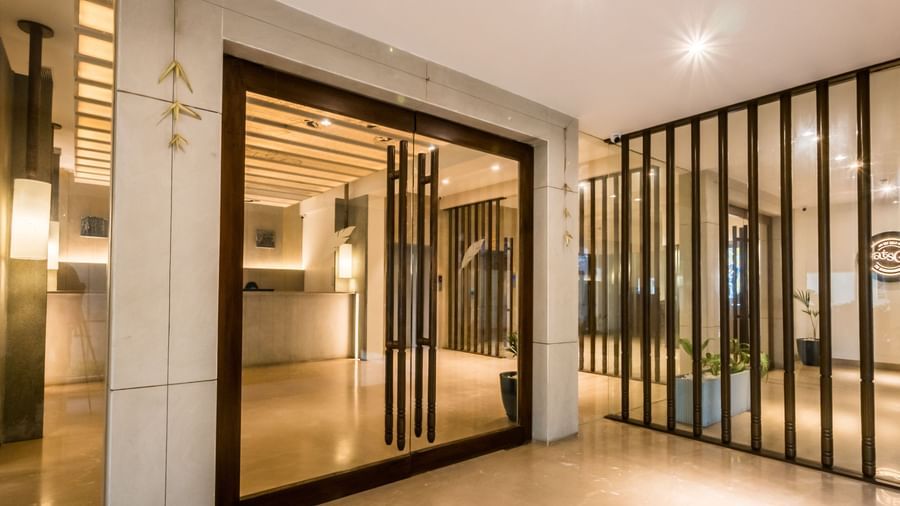 The grand entrance to a contemporary building with large glass doors and sleek wooden accents at Shilton Dee Cee.