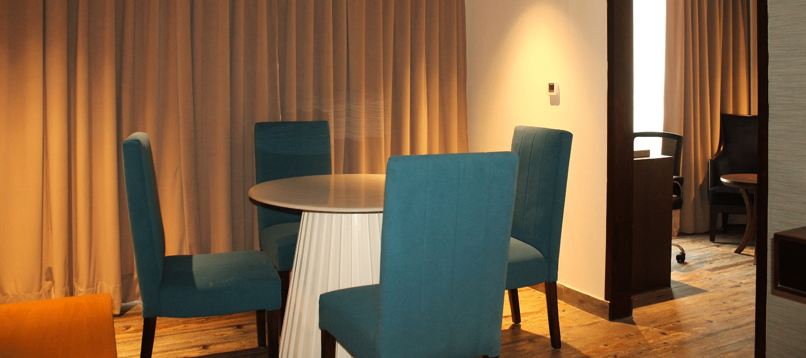 Close-up view of the dining space in the suite featuring a table and chairs at BluSalzz Residence, Amritsar.