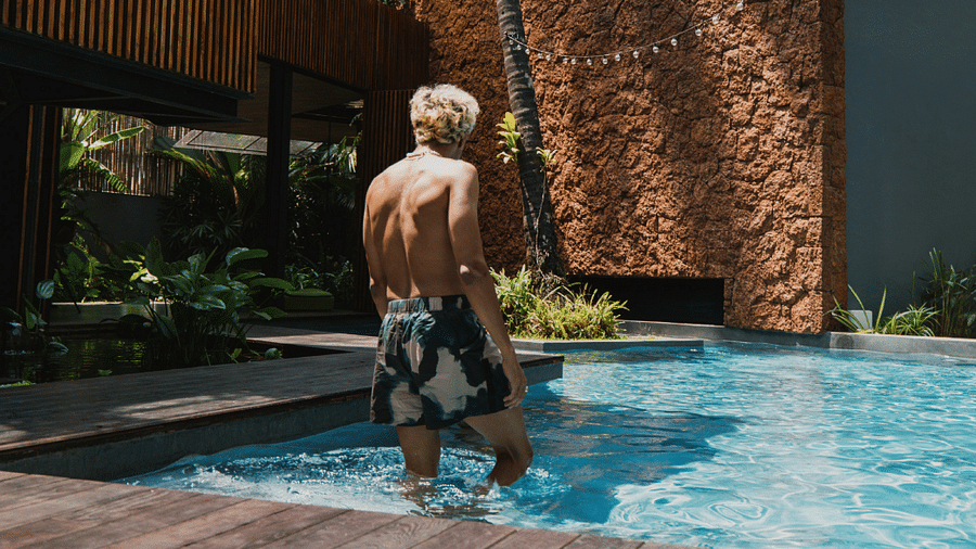Man enjoying a refreshing dip in a private pool at a luxury tropical retreat