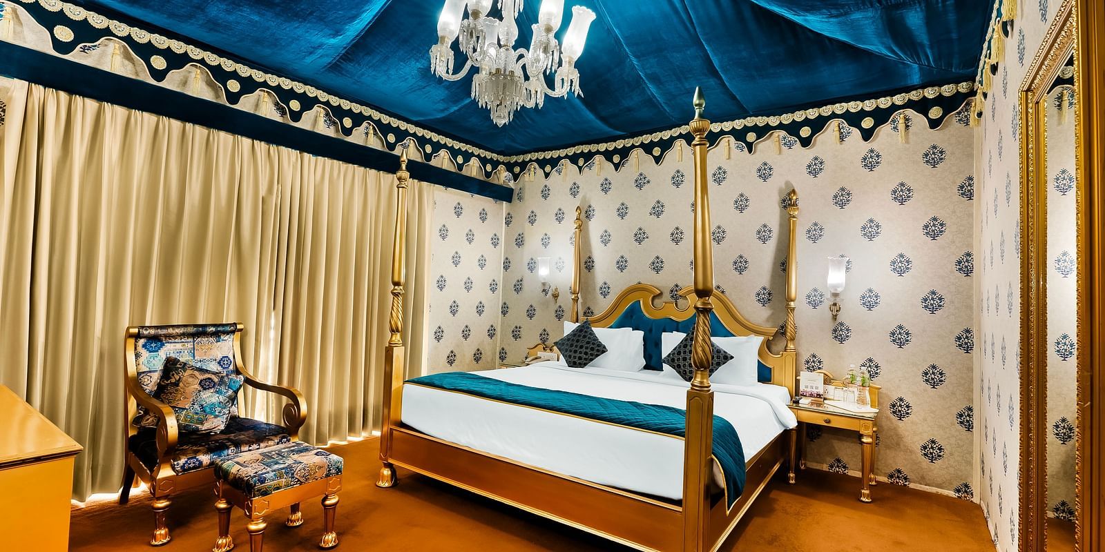 An overview of a tent with a double bed, a chair and a small table - Rajasthali Resort & Spa, Jaipur.