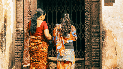 a over the shoulder shot of two women entering the temple