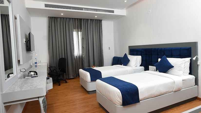 A full view of twin beds with bedding in a spacious room