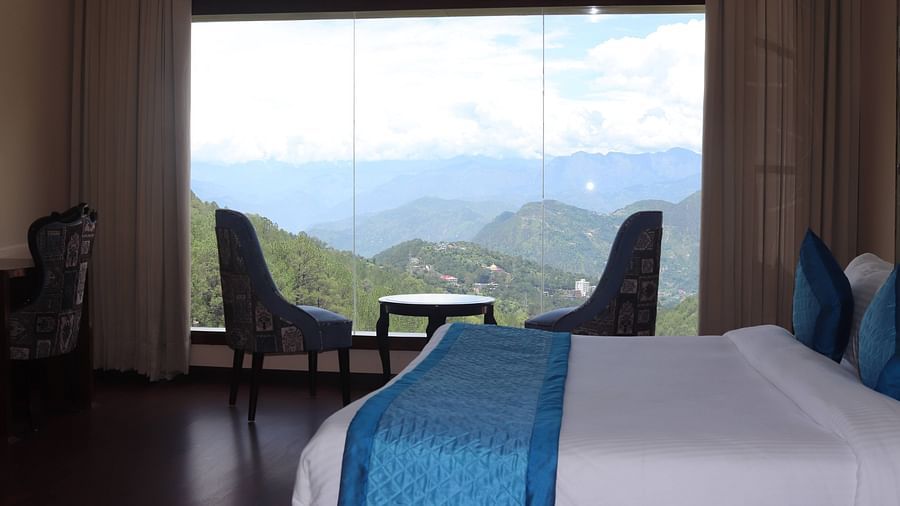 Seating area with coffee table along with scenic view from the window - Mastiff Hotel, Dalhousie