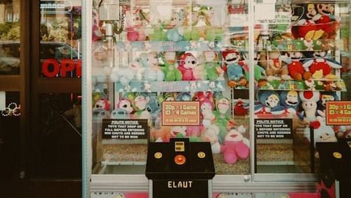 Close-up of a claw machine with prizes inside.
