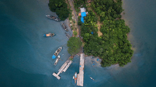 An aerial view of Port Blair with boats, trees and a road in view