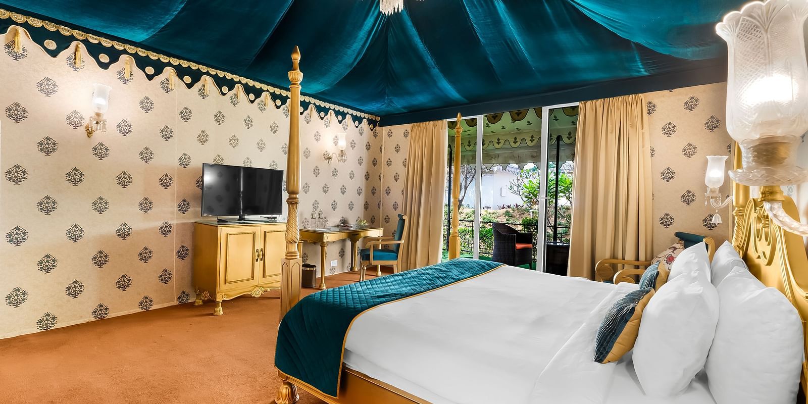 An overview of a tent with a double bed and a tv in front of it - Rajasthali Resort & Spa, Jaipur.