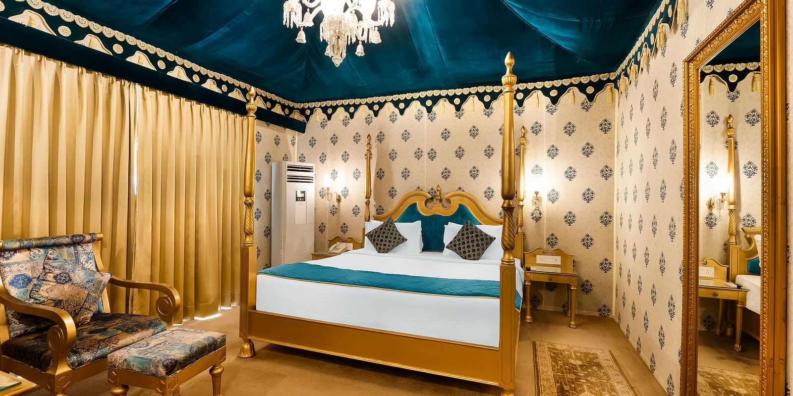 An overview of a tent with a double bed, a chair and a table seen inside it - Rajasthali Resort & Spa, Jaipur.