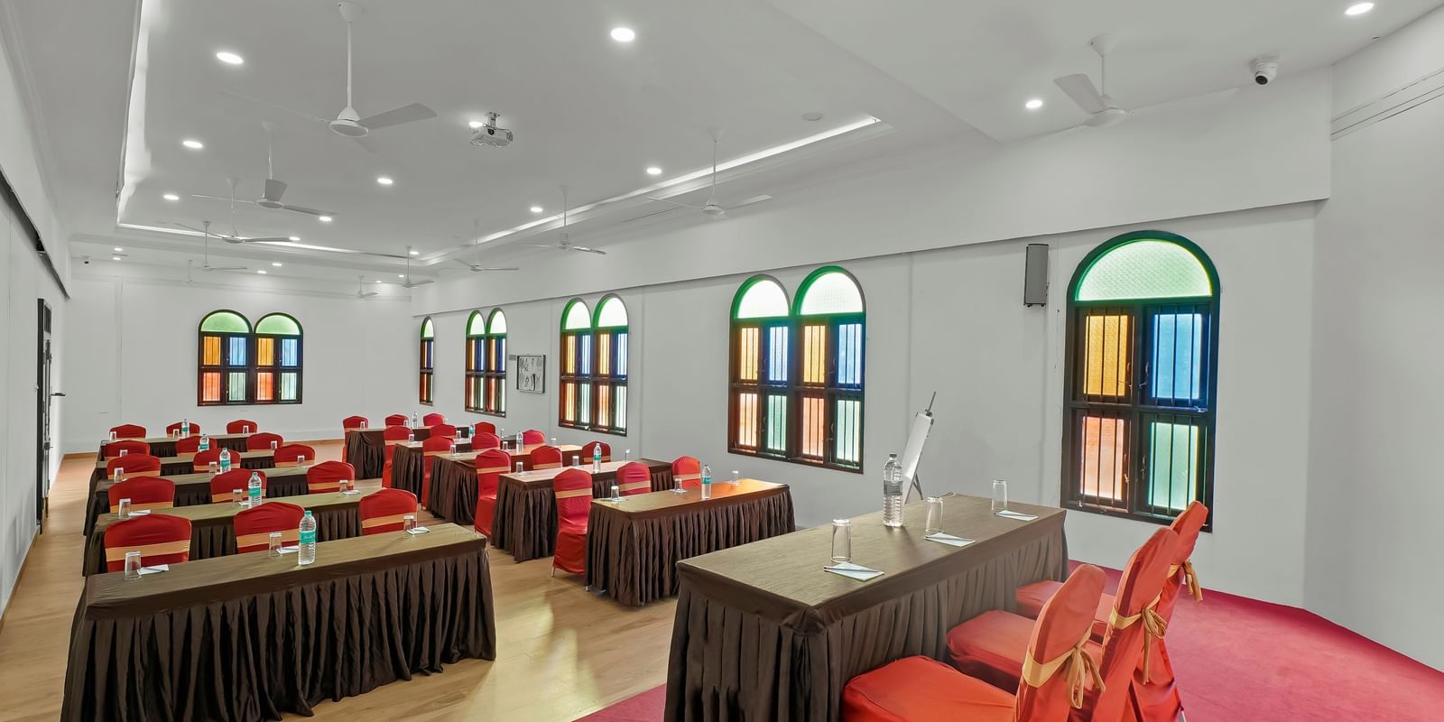Diagonal view of a banquet hall with tables and chairs arranged for an event at WOW Bungalow, Yercaud.