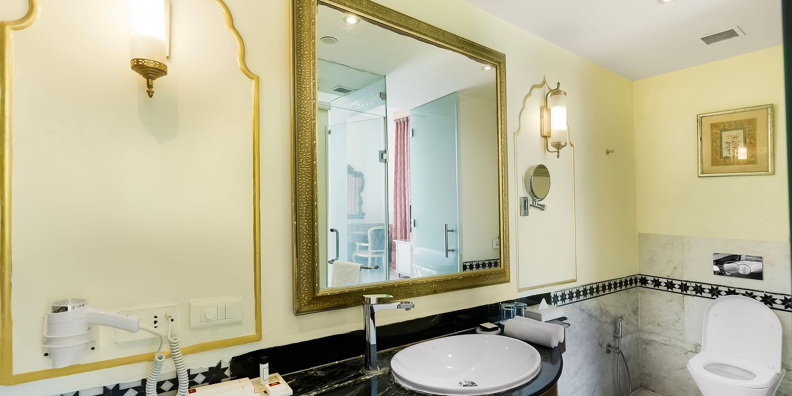Elegant bathroom at Rajasthali Resort Jaipur featuring grand arch mirror, premium fittings, and refined interiors.