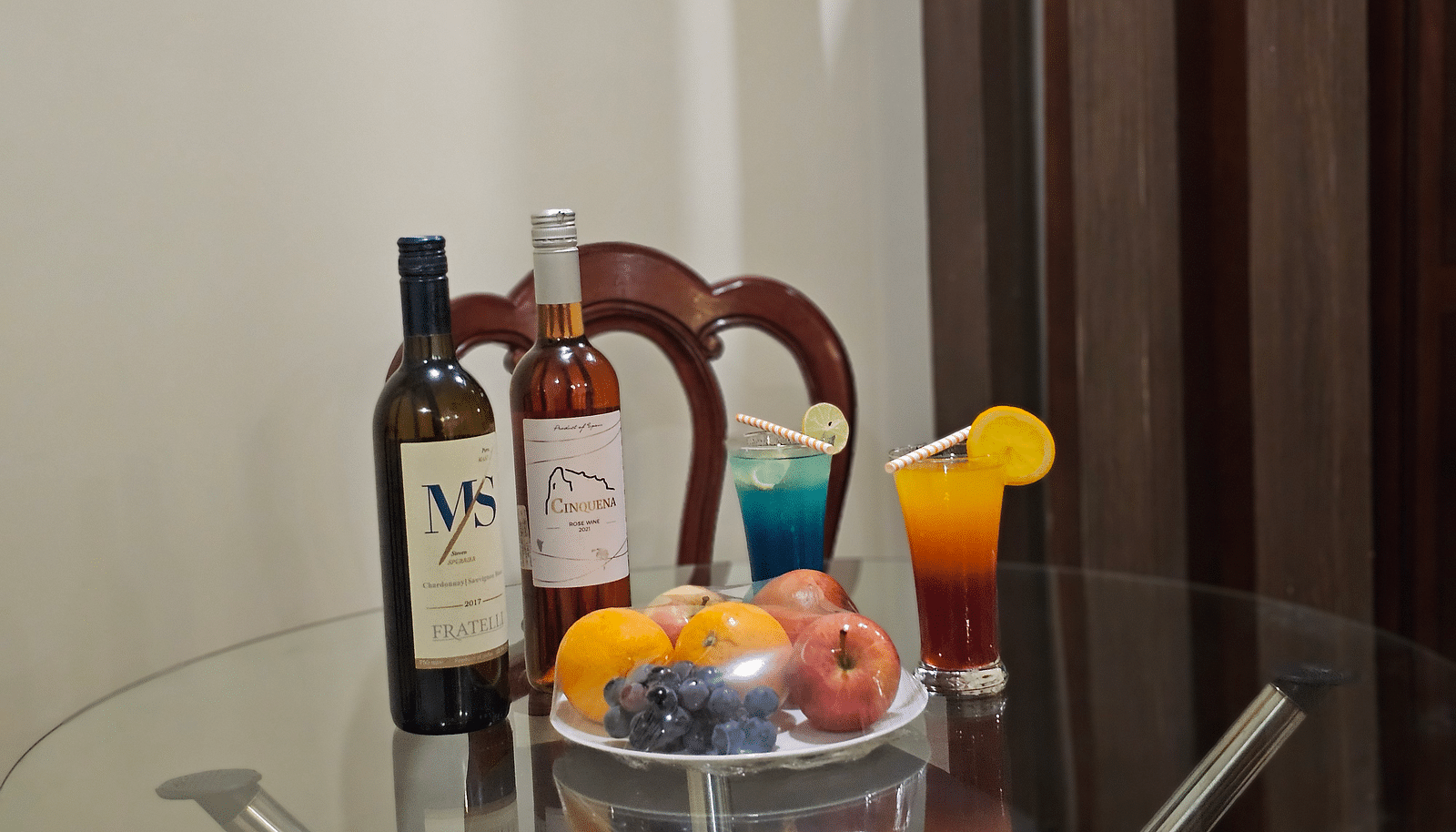 An image of a table which has fruits and some bottle placed at the centre - Sathyam Grand Resort