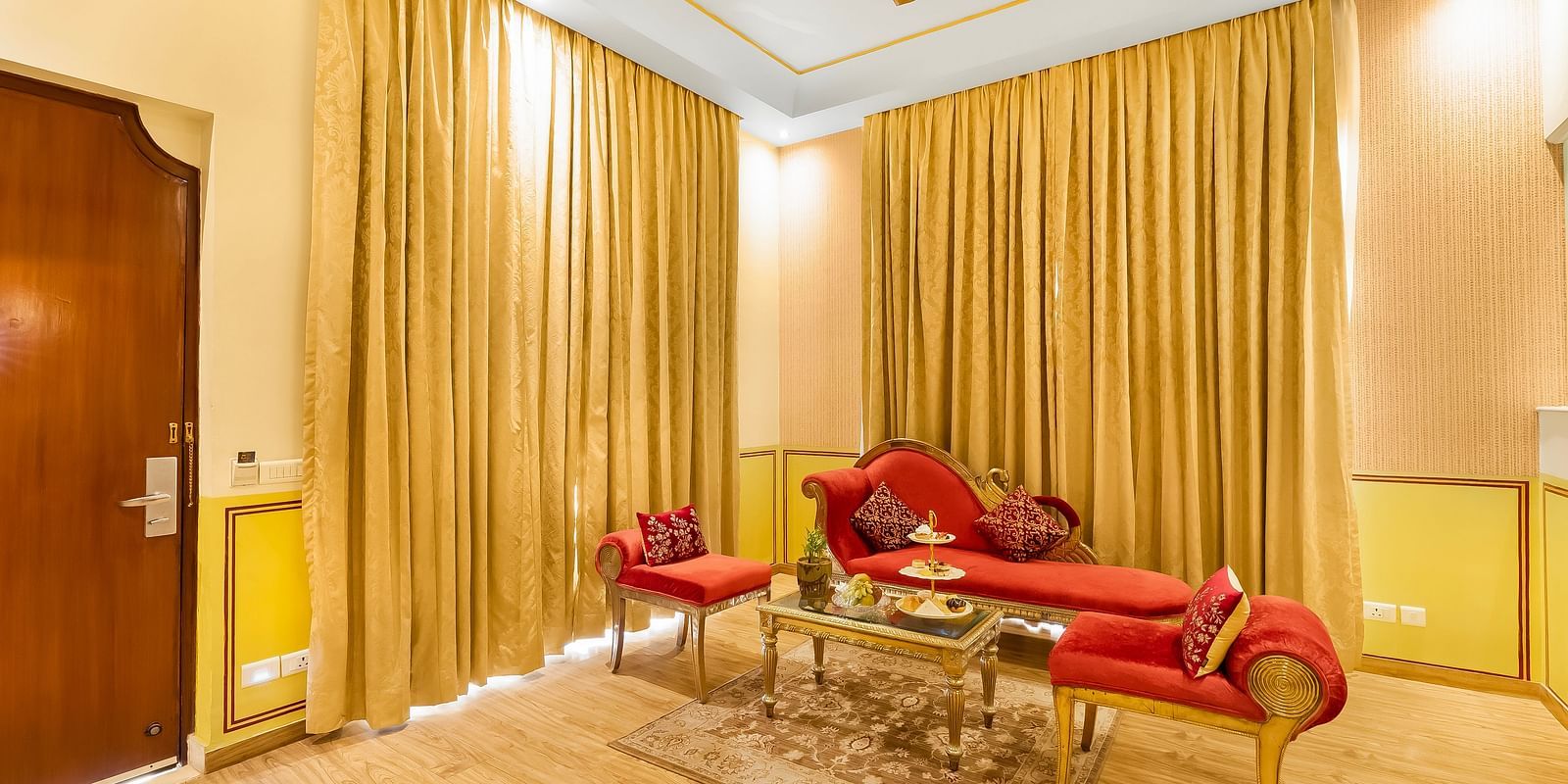 An overview of a living room inside a room with sofas and a table inside it - Rajasthali Resort & Spa, Jaipur.