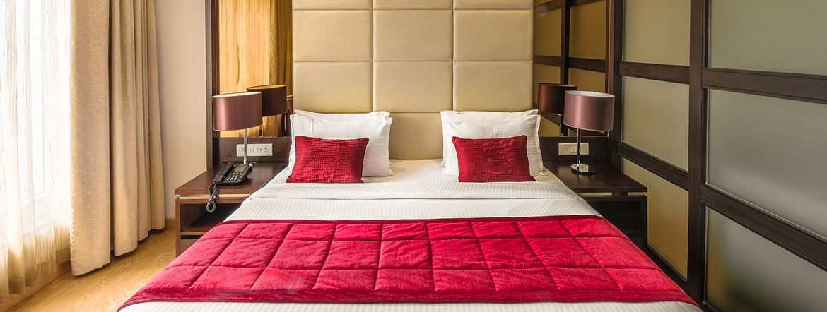 A Hotel bedroom with large bed, red bedspread and padded headboard - TGI Grand Fortuna, Hosur