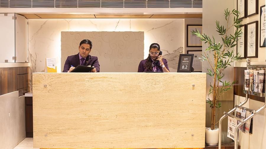 A front view of the reception area, with the receptionist standing at the desk, ready to assist customers in a welcoming environment.