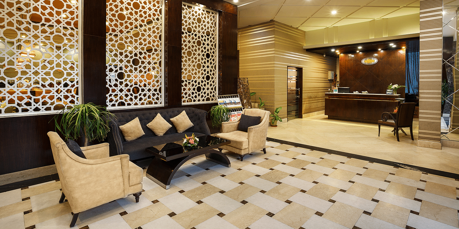 A sophisticated hotel lobby featuring a geometric patterned boards, plush seating, and a reception desk - The Manor, Bareilly