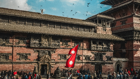 Many people gathered around a monastery where a flag of Nepal is also hoisted | Kavya Resort and Spa, Nagarkot