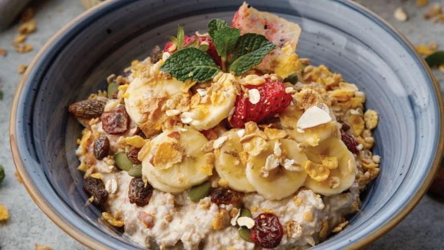  A bowl of healthy breakfast consisting slices of banana, raisins, strawberries, muesli,  corn, etc. | Kavya Resort and Spa, Nagarkot